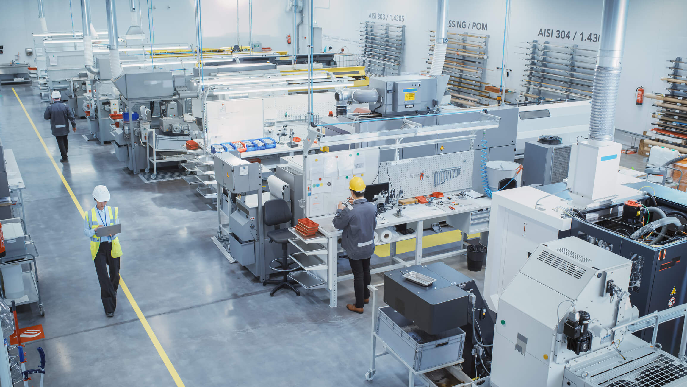 Elevated view of a clean, organised factory floor with machines and workers walking marked aisles.